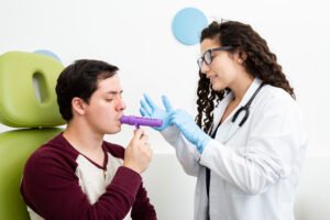 Paciente masculino realizando test de aliento soplando en dispositivo médico asistido por médica especialista en gastroenterología, prueba para diagnóstico de SIBO e intolerancia a la lactosa en Cartagena
